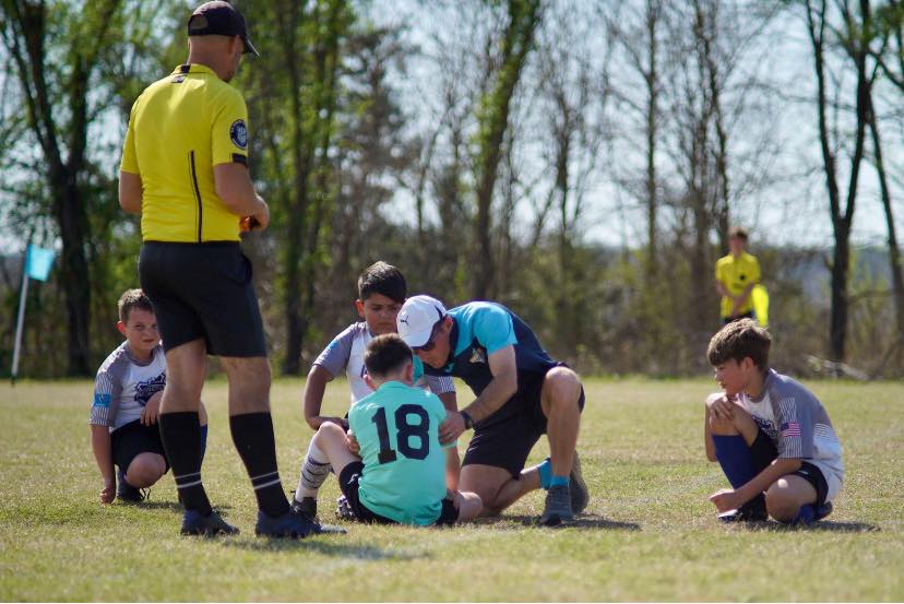 Coach caring for a player on the field